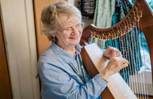 Therapeutic harp practitioner Margaret Stephens playing the harp